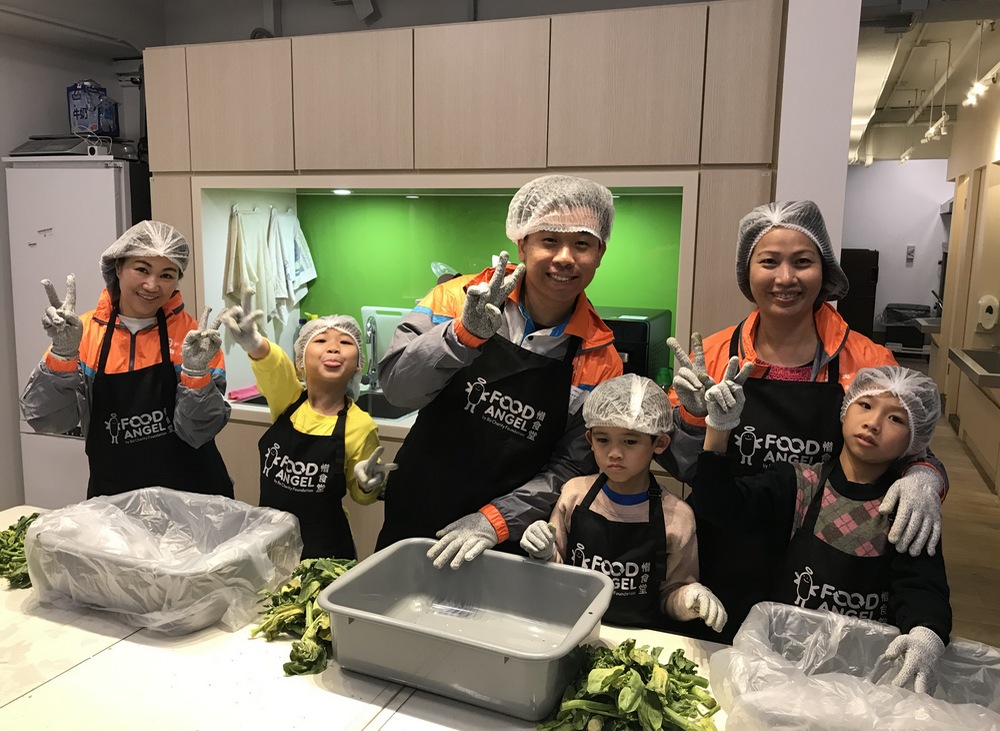 Volunteers and children help prepare  meal boxes for the elderly